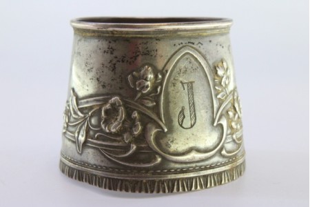  Argola de guardanapo em prata em forma de punho e relevada com motivos florais envolvendo cartela para monograma.